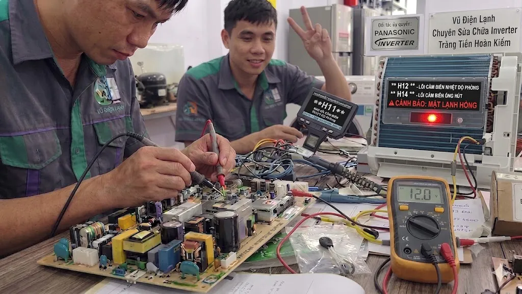 Kỹ thuật viên Vũ Điện Lạnh đang dùng đồng hồ vạn năng đo kiểm trị số cảm biến và khắc phục lỗi bo mạch điều hòa Panasonic Inverter báo lỗi nháy đèn tại căn hộ ở khu vực đường Tràng Tiền quận Hoàn Kiếm