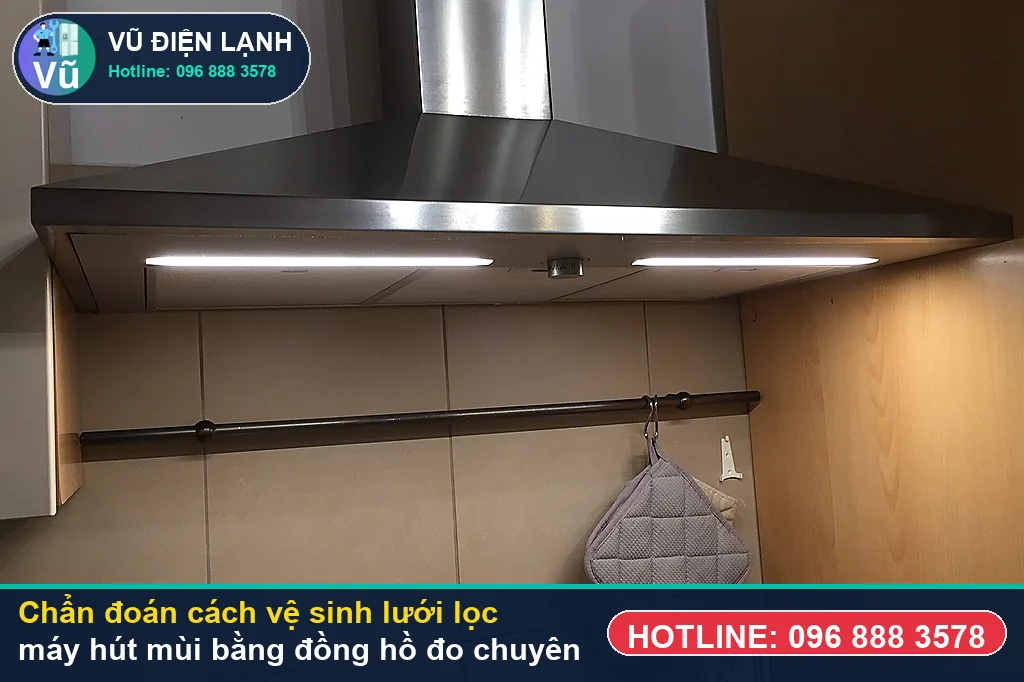 Thợ Vũ Điện Lạnh dùng đồng hồ vạn năng đo kiểm mô-tơ tuabin, tụ đề và bo mạch khi xử lý cách vệ sinh lưới lọc máy hút mùi