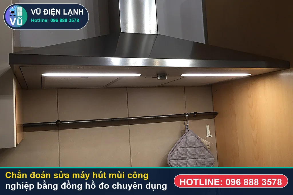 Thợ Vũ Điện Lạnh dùng đồng hồ vạn năng đo kiểm mô-tơ tuabin, tụ đề và bo mạch khi xử lý sửa máy hút mùi công nghiệp