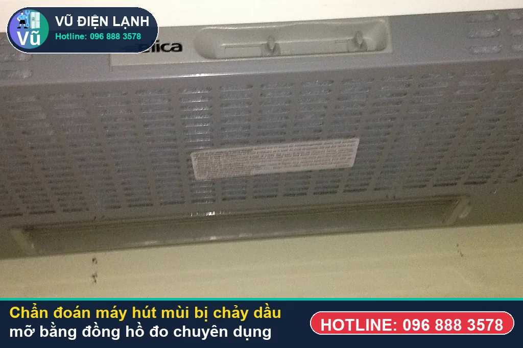 Thợ Vũ Điện Lạnh dùng đồng hồ vạn năng đo kiểm mô-tơ tuabin, tụ đề và bo mạch khi xử lý máy hút mùi bị chảy dầu mỡ