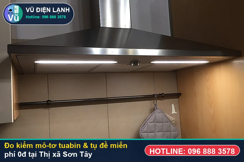 Thợ Vũ Điện Lạnh dùng đồng hồ vạn năng đo kiểm mô-tơ tuabin, tụ đề và công tắc khi sửa máy hút mùi tại sơn tây ở KĐT HUD Sơn Tây